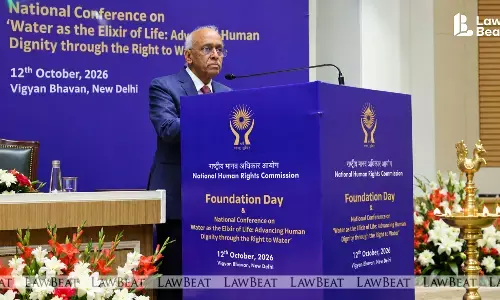 Justice V. Ramasubramanian, Chairperson of the National Human Rights Commission, speaking at a podium at the NHRC Foundation Day event, with Chief Justice of India Surya Kant seated on the dais.